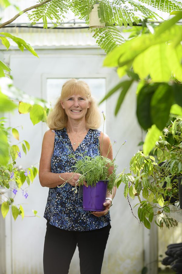 woman standing holding plant