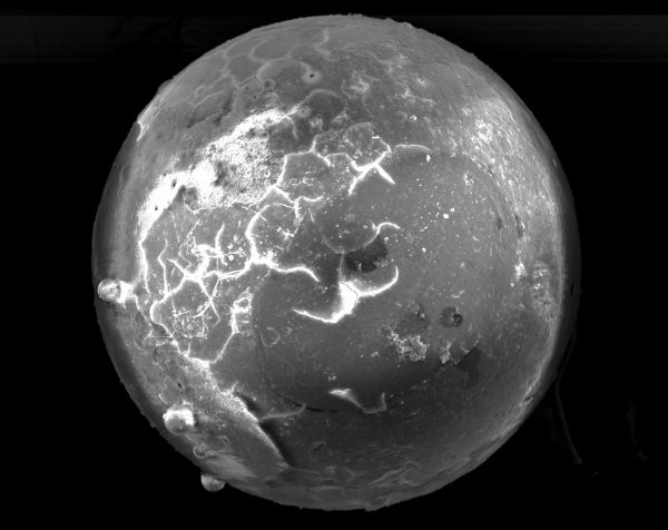 scanning electron image of glass sphere with cracks