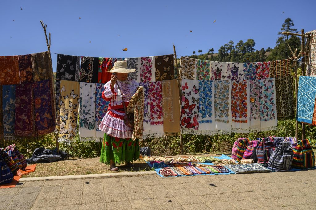 woman sews in front of textiles