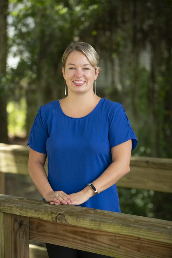 woman in blue dress standing on outdoor boardwalk