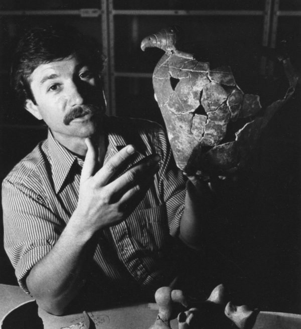 researcher holding reconstructed pottery vessel in museum lab