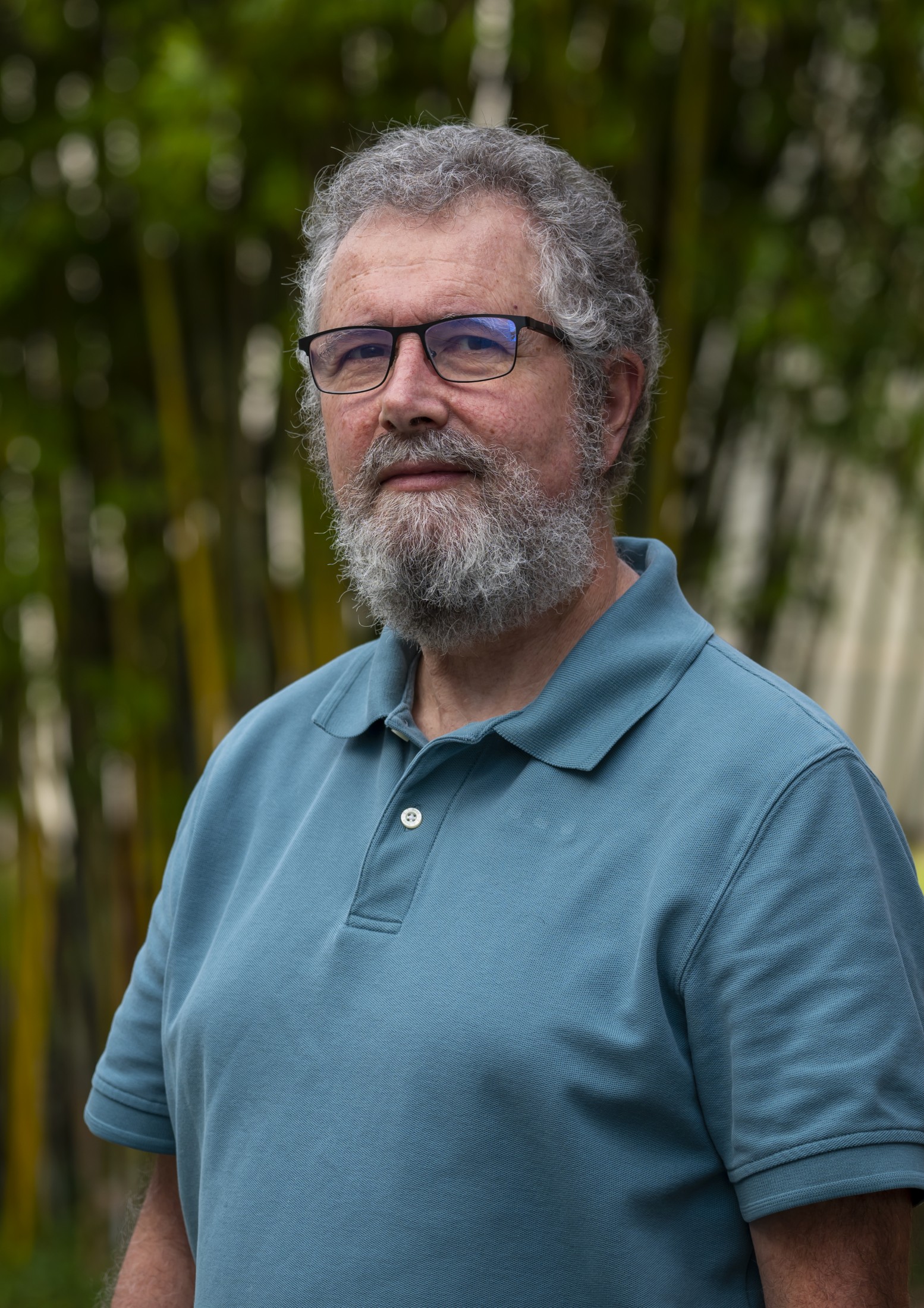 Man stands in front of bamboo trees outside