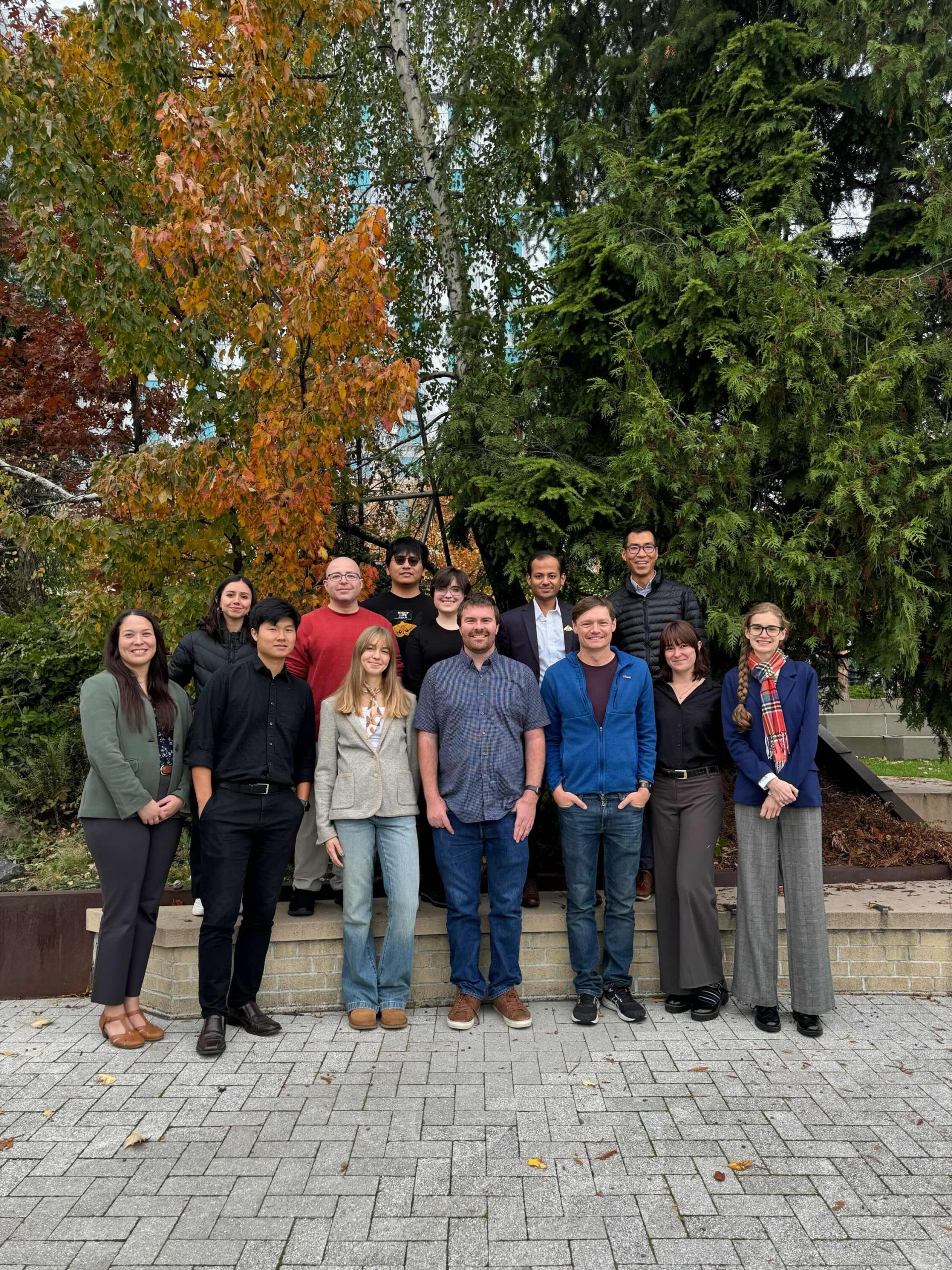 Group of people stand outside and pose for a photo. 
