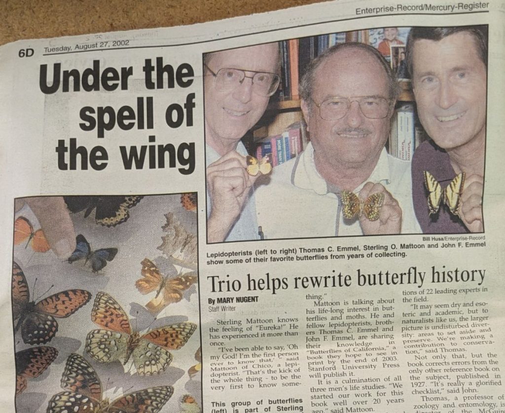 Newspaper article with the headline, "Trio helps rewrite butterfly history," with a photo of three people standing close together and holding butterflies.