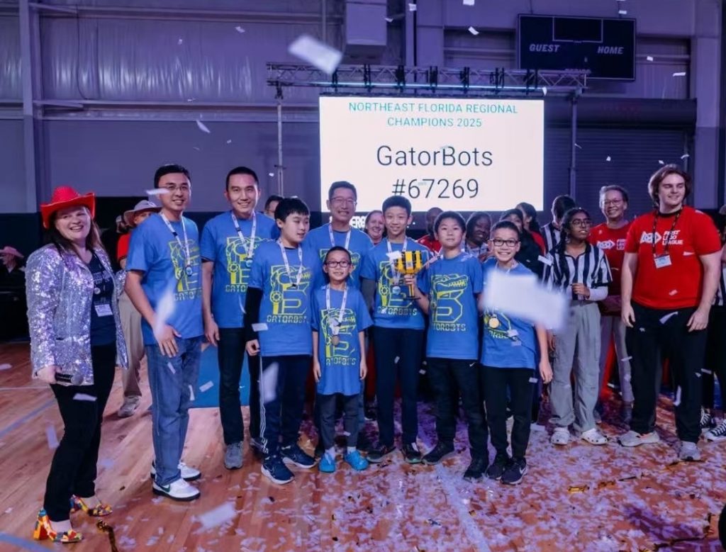 Photograph of several kids and adults wearing blue team t-shirts and medals while confetti falls around them.