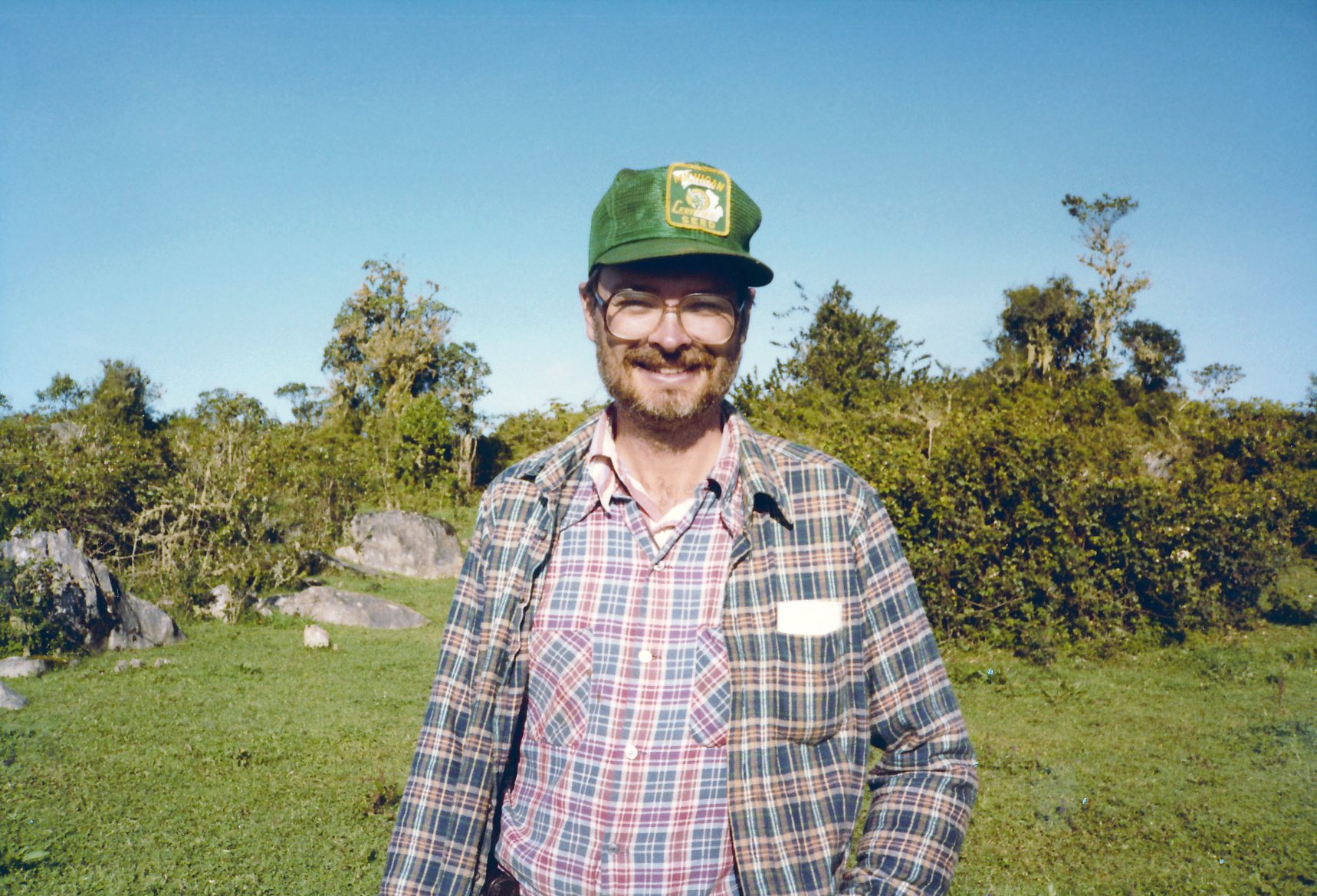 Photograph of person standing outside with a hat on and multiple shirt layers.