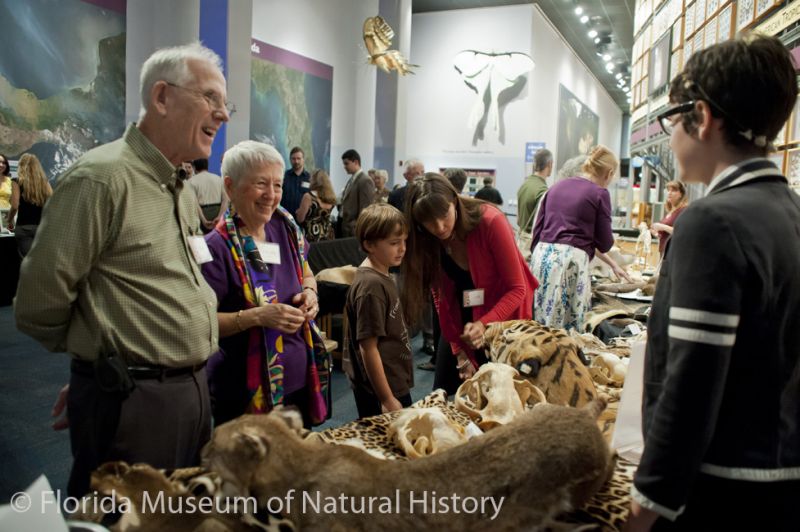 visitors talk with a student over specimens