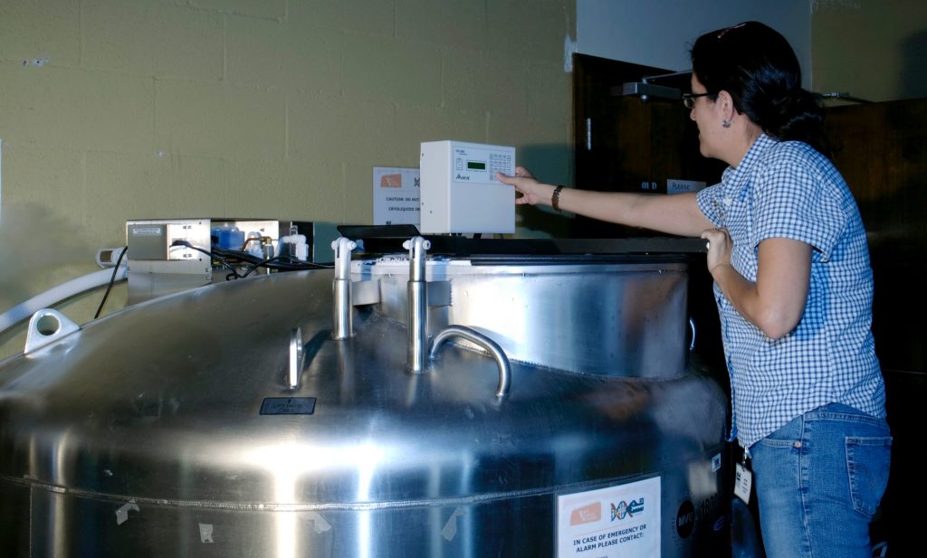 person entering numbers onto the keypad above the freezer