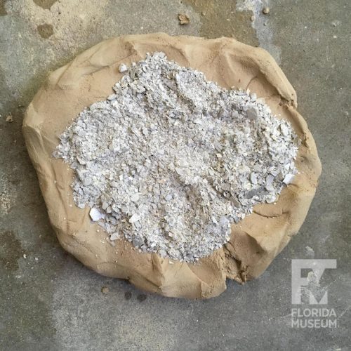 clay with pile of gray crushed shell on top