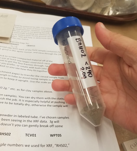 hand holding a vial