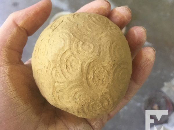ball of clay with stamped design