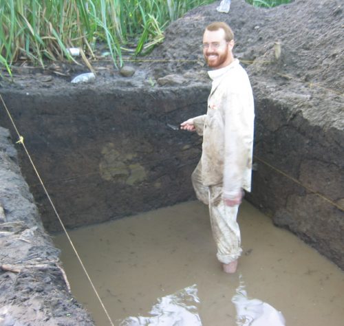 Man standing in excavation unit with water up to knees