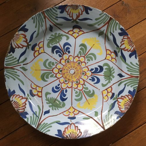 Polychrome tin-enameled earthewnare charger with star/botanical decoration