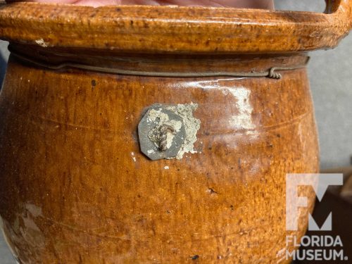handled earthenware vessel with metal repair