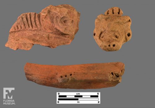 Formal Artifact photo with two adorno effigies and one incised appliqué.