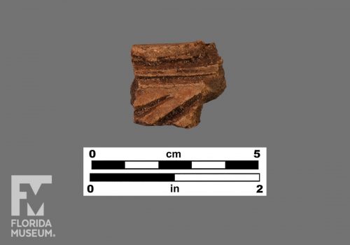 Formal artifact photo of a sherd with horizontal and diagonal incising.