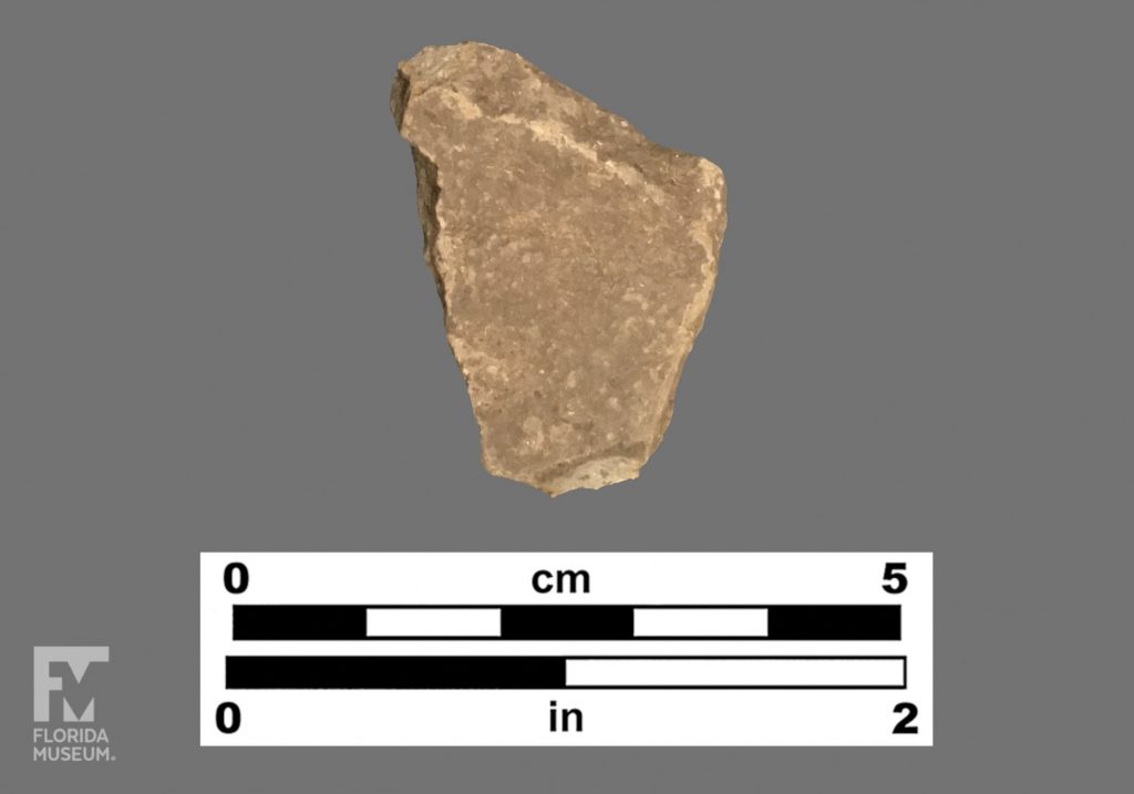 Formal artifact photo of an undecorated tan colored sherd.