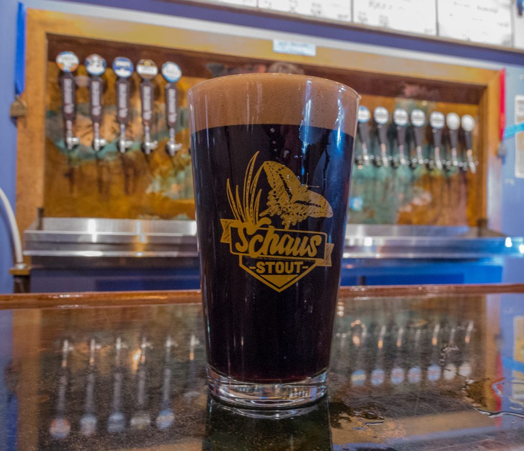 Schaus Stout beer in its custom beer glass sits on the bar top at First Magnitude Brewery