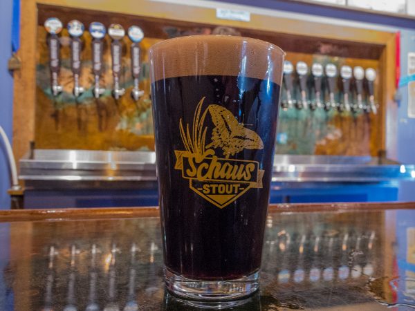 Schaus Stout beer in its custom beer glass sits on the bar top at First Magnitude Brewery
