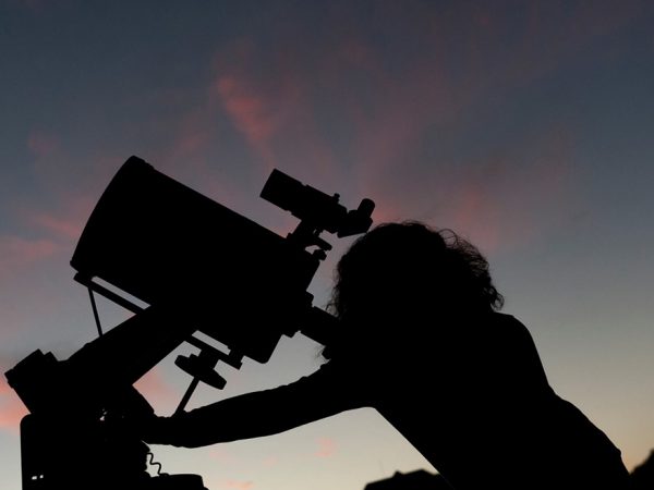 silhouette looking through telescope