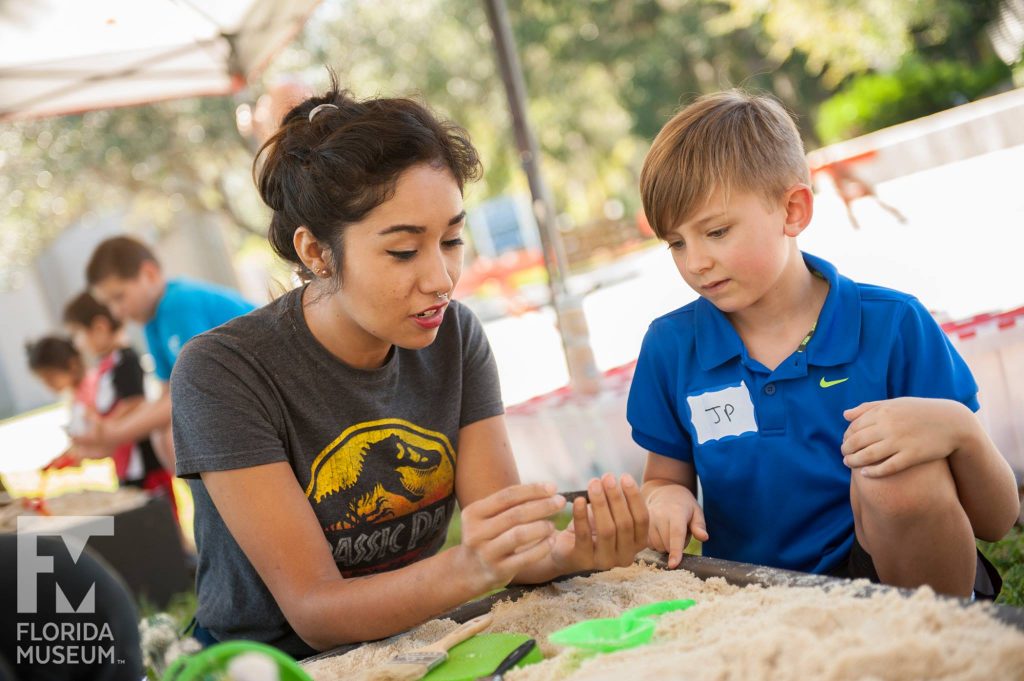 kid learning in fossil dig station