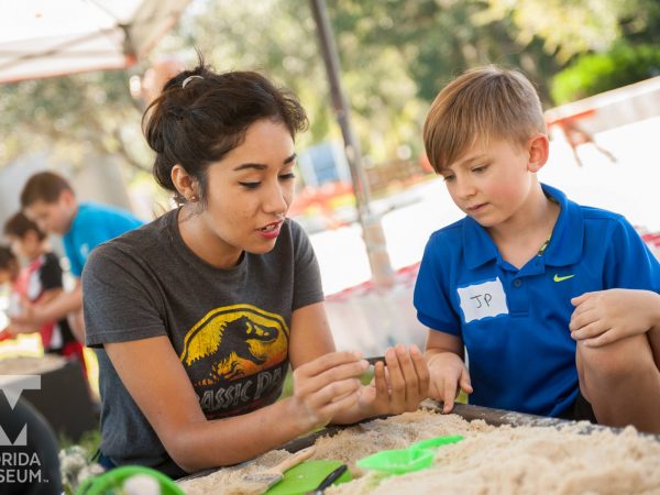 kid learning in fossil dig station