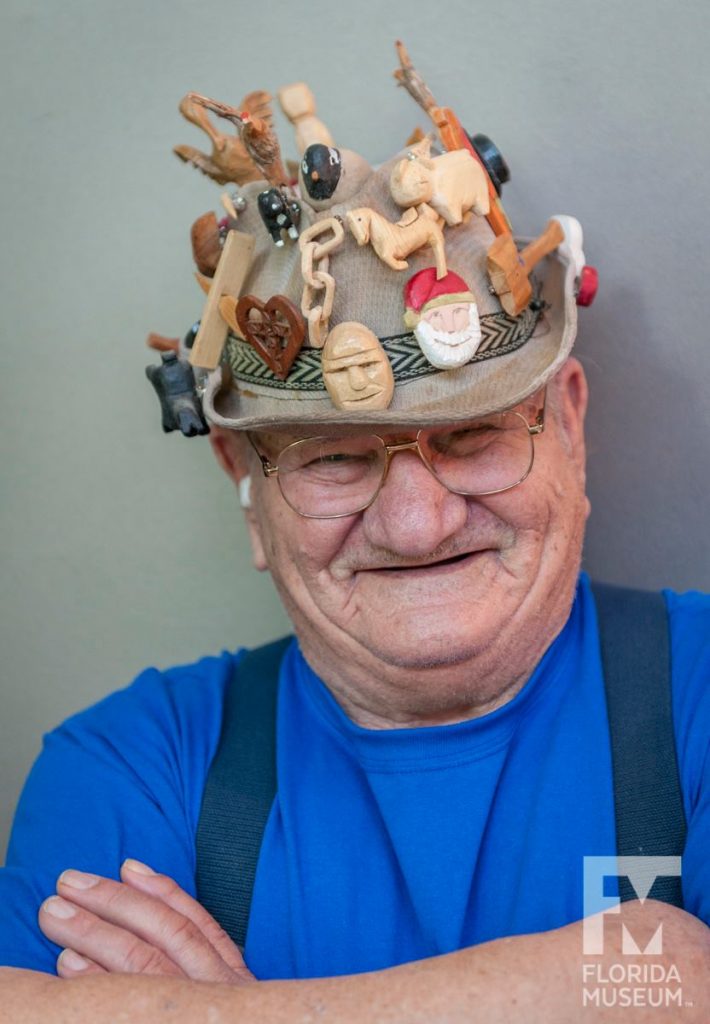 man with hat covered in pins