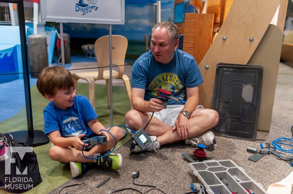 father and son building robot