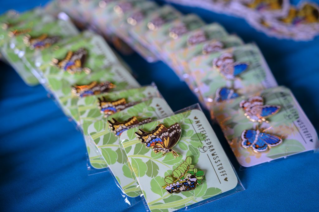 cards with butterfly and caterpillar pins are lined up on a table