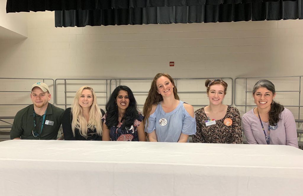 six educators and researcher sitting behind a table in a school auditorium