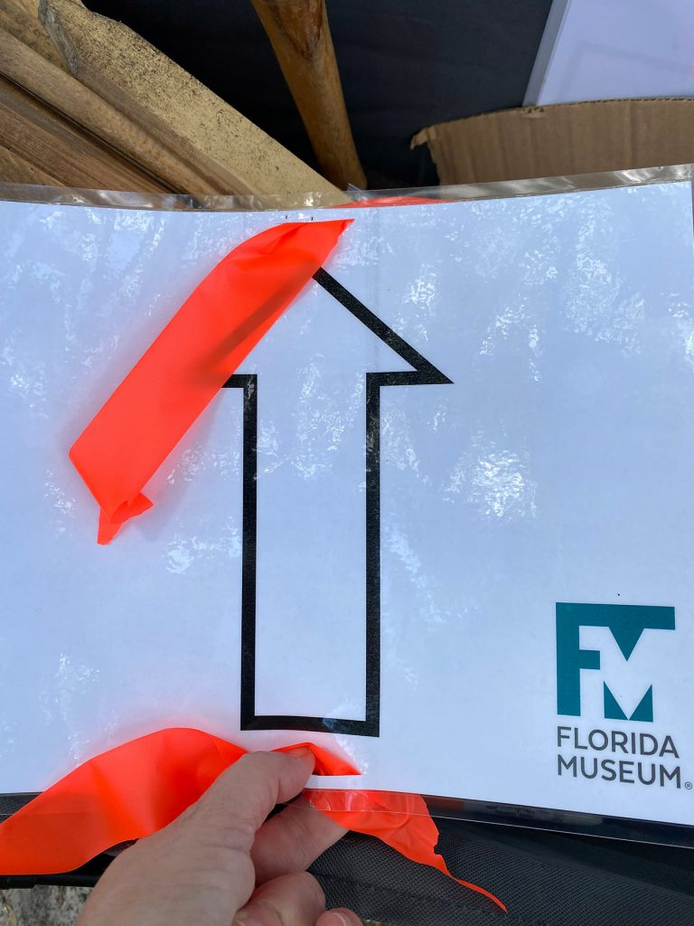 a laminated arrow sign ready to be placed outside for a race