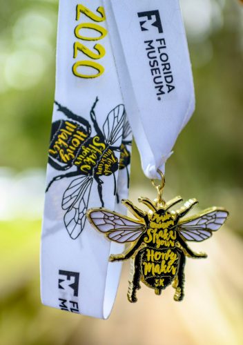 a 5k race medal shaped like a bee