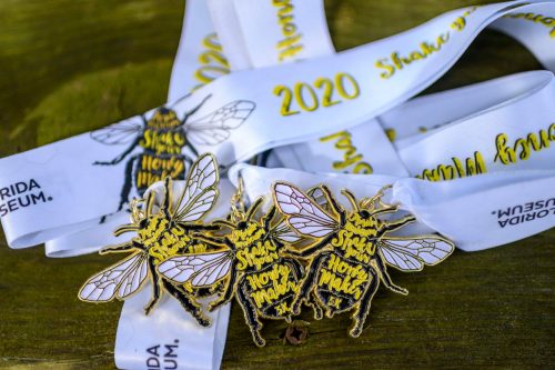 several 5k medals shaped like bees