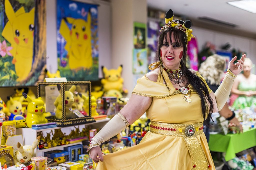 A woman dressed in cosplay with her Pikachu collection.