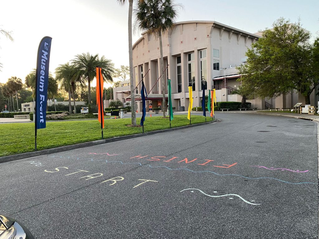 the start and finish line written in chalk in front of the museum, Phillips center can be seen behind the start/finish line
