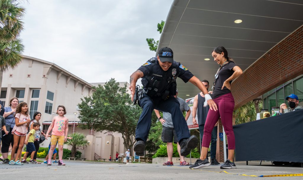 UFPD officer in uniform participates in the frog jump competition