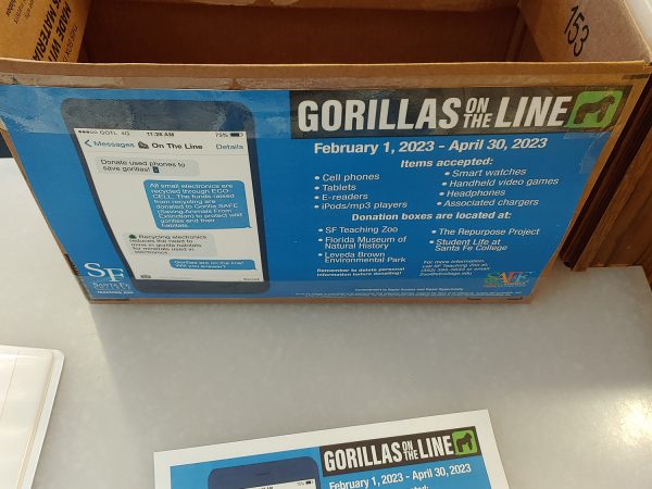 the box in the Florida Museum lobby with a Gorillas on the line poster on the side of the box and on the table in front of the box