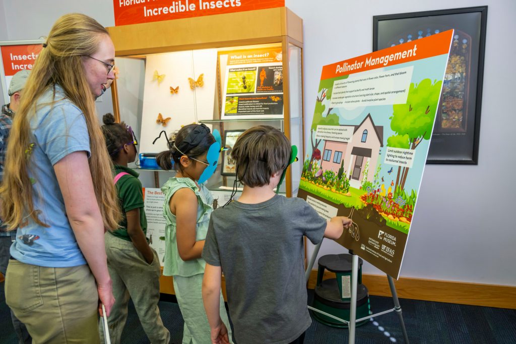 Young visitors look at a Pollinator Management display sign