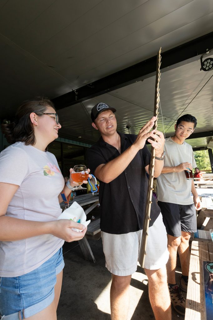 Joe Miguez shows a saw tooth specimen to a person at the brewery