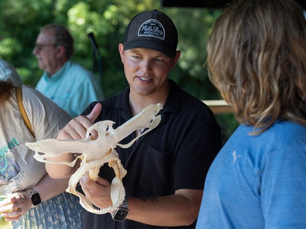 Joe Miguez showing a shark head skeleton to people at the brewery