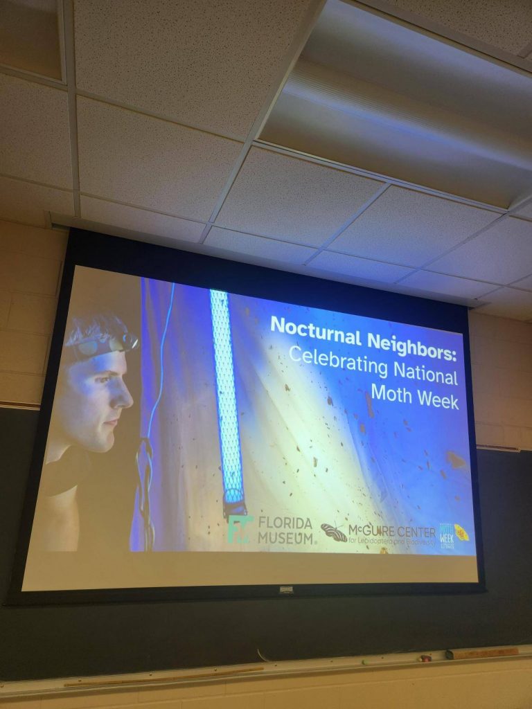 projected screen with the text Nocturnal Neighbors: celebrating national moth week.
