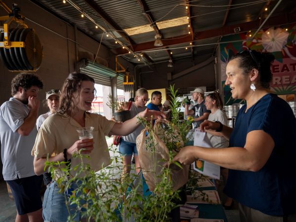 researchers handing plants to visitors
