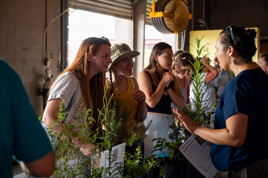 People speaking with Daniels lab researcher about the native plants in the plant giveaway