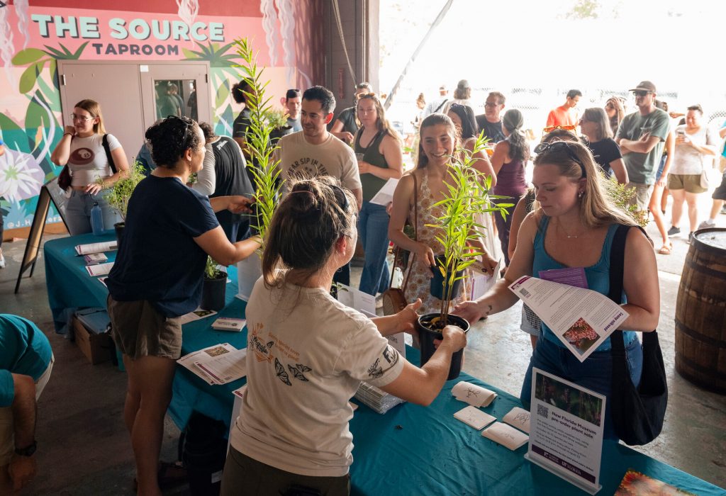 researchers handing plants to visitors