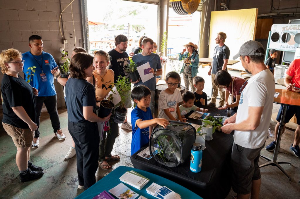 visitors look at insects on display during Pollinator Palooza