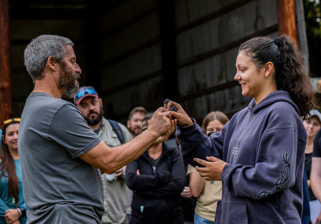 researcher shows an event participant how to hold a captured bird