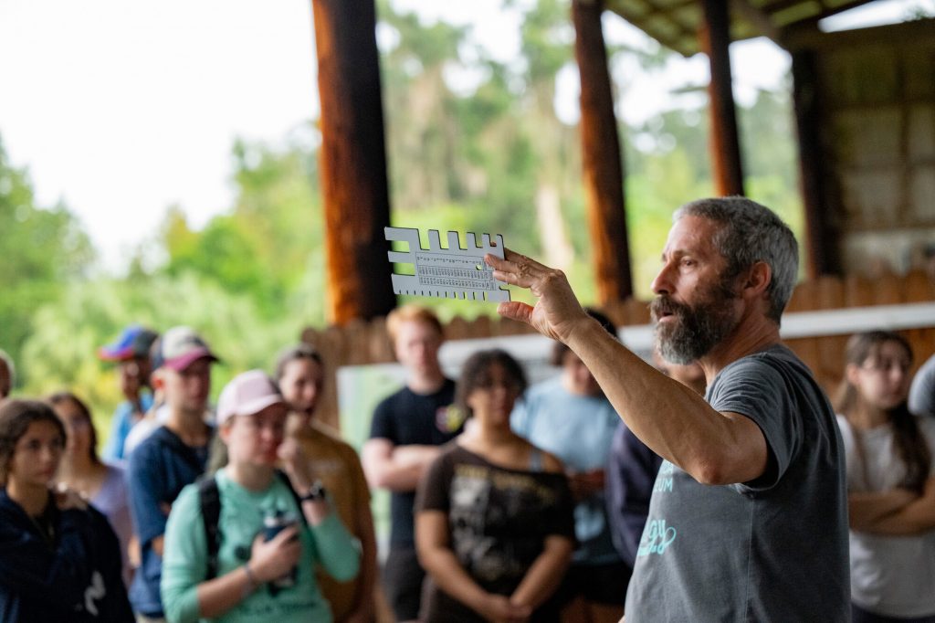 Charlie Muise holding up the tool used to measure birds for banding