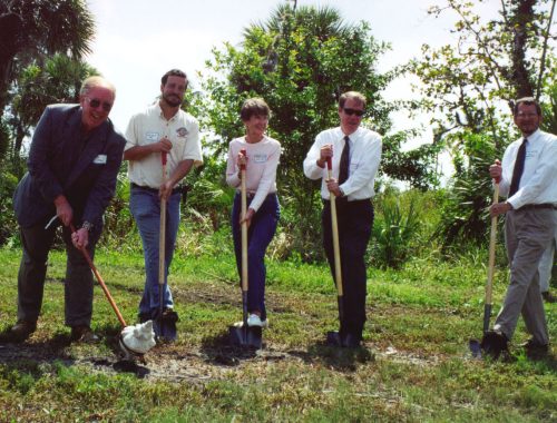 five people holding shovels for the ground breaking ceremony