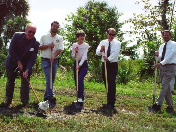 five people holding shovels for the ground breaking ceremony
