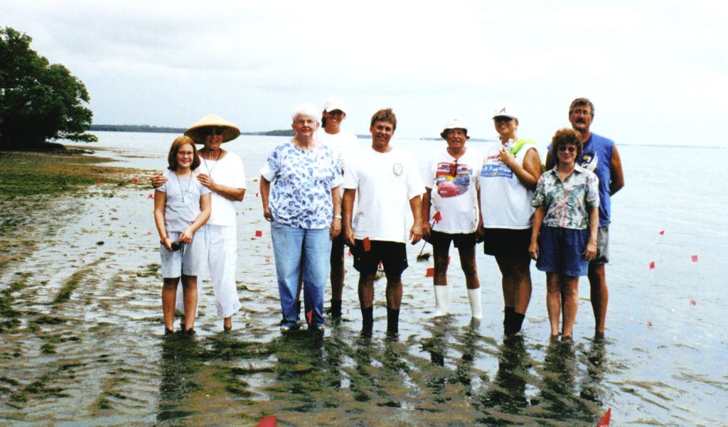 group photo of people standing in shallow ankle-deep water. 